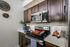 Contemporary kitchen with sleek stainless steel appliances, rich wooden cabinets, and stylish decorative accents.