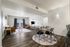 Bright and modern open-concept living space featuring elegant hardwood floors, contemporary furnishings, and a cozy dining area.
