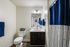 Elegant bathroom featuring modern fixtures, sleek dark wood vanity, and stylish blue accents.