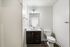 Bright, modern bathroom featuring a sleek white vanity with a large mirror and elegant lighting.