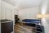 Sleek and modern bedroom with stylish furnishings, featuring a comfortable bed, cozy desk area, and warm lighting, perfect for relaxation and productivity.