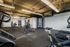 Modern fitness center featuring state-of-the-art exercise equipment, well-lit open space, and sleek industrial ceiling design.