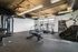 Modern gym with state-of-the-art fitness equipment, including treadmills, weight machines, and ample natural light, perfect for a revitalizing workout.