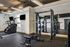 Modern fitness center with cutting-edge gym equipment, featuring a Smith machine and elliptical trainer in a spacious room with ample natural light.