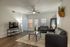 Contemporary living room with modern furnishings, sleek leather sofas, elegant decor, and abundant natural light from large windows.