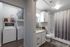 Modern apartment laundry and bathroom combo featuring a sleek washer-dryer set and a chic bathroom with a granite countertop and elegant d&eacute;cor.