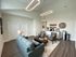 Modern and inviting living area with sleek dark wood flooring, comfortable grey sofa, and stylish lighting for a cozy ambiance.