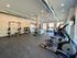 Modern fitness center with state-of-the-art cardio machines, weightlifting equipment, and abundant natural light.