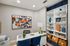 Contemporary home office with vibrant abstract art and sleek shelving, showcasing a stylish workspace.