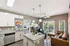 Modern open-concept apartment featuring a stylish kitchen with granite countertops, cozy living room with leather seating, and access to a private balcony offering lush views.