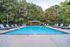 Inviting outdoor pool area with relaxing lounge chairs, surrounded by lush greenery and a charming gazebo.