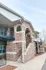 Charming brick apartment exterior with elegant archways and spacious balconies in a serene neighborhood setting.