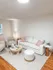 Chic and cozy living room with plush white seating, a modern coffee table, and soft ambient lighting, perfect for relaxation and entertaining.