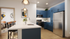 Sleek modern kitchen with blue cabinets, stainless steel appliances, and chic pendant lighting, adjoining a cozy bedroom.