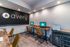Modern co-working office space with wooden desks, stylish chairs, and sleek computer setups under warm lighting.