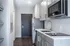 Contemporary kitchen design with sleek gray cabinetry, modern appliances, and elegant dark wood flooring.