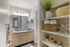 Bright and modern bathroom with dual sinks, elegant decor, and ample shelving for a luxurious feel.