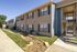 Bright and inviting apartment exterior with charming architecture, featuring landscaped pathways and easy access staircases.
