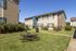 Charming apartment exterior surrounded by lush greenery, featuring a cozy picnic area for outdoor relaxation.