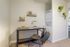Charming home workspace with modern desk and shelves, complemented by a convenient in-unit laundry area.