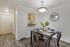 Inviting dining area with modern decor, elegant lighting, and a pass-through kitchen window, perfect for entertaining.