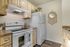 Charming kitchen with light wood cabinets, sleek white appliances, and elegant decor accents, offering a cozy and inviting cooking space.