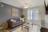 Bright and inviting modern living room with a cozy gray sofa, stylish decor, and ample natural light streaming through sheer curtains.