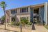 Charming exterior of a modern apartment building with lush landscaping and convenient resident parking.