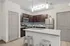 Modern kitchen with sleek dark cabinets, stainless steel appliances, and an inviting breakfast bar with stylish pendant lighting.