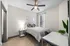 Elegant bedroom featuring modern decor, wooden flooring, and natural light from a large window.