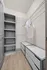 Spacious walk-in closet featuring modern shelving and storage solutions with elegant wooden flooring.