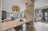 Chic modern living area with stylish pendant lighting, a pool table, and large windows overlooking a vibrant outdoor space.