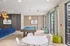 Modern leisure room at Altitude featuring a vibrant blue pool table, stylish lighting, and contemporary decor with large windows offering ample natural light.