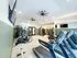 Modern fitness center featuring state-of-the-art treadmills, ellipticals, and strength training equipment in a spacious, well-lit room.