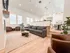 Bright and spacious open-concept living area featuring modern furniture, cozy seating, and natural light flowing through large windows.