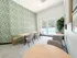 Bright and modern communal dining area with vibrant green accent wall, overlooking a sparkling pool through large windows.