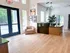 Bright and modern apartment lobby featuring elegant lighting, a welcoming seating area, and sleek wooden flooring.