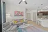 Chic open-concept living room with modern gray sofa, vibrant wall art, and elegant kitchen in background, highlighting contemporary design.