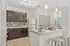 Modern kitchen with sleek dark cabinets, colorful mosaic backsplash, and a gleaming stainless steel refrigerator. Bright and inviting counter space with a stylish snack bar and contemporary lighting.