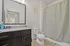 Contemporary bathroom featuring a sleek vanity, spacious mirror, and elegant shower curtain.