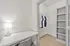 Modern apartment featuring a walk-in closet with built-in shelves and a cozy desk area, ideal for organizing and working.