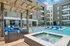 Luxurious apartment community showcasing a modern pool area with stylish loungers, shaded seating, and pristine architecture for ultimate relaxation.