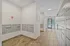 Modern apartment lobby with sleek mailboxes and secure parcel lockers, featuring bright lighting and stylish tiled flooring, near an exit door leading outside.