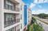 Modern apartment building with private balconies at Altitude, offering scenic views of the surrounding greenery and city street.
