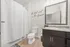 Modern bathroom with sleek vanity, elegant mirror, and stylish decor, featuring 'the best seat in the house' wall art.