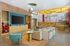 Vibrant community lounge with cozy seating, modern decor, and a lively mural in a stylish apartment complex.