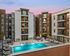Modern apartment complex with a scenic sunset backdrop, featuring a pristine pool surrounded by stylish lounge chairs and contemporary architecture.
