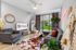 Modern living room with stylish decor, featuring a cozy gray sofa, chic wall art, and a large window overlooking a lush garden.