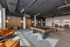 Modern open-concept recreational room with stylish wooden pool table, vibrant orange lounge chairs, sleek wall art, and ambient lighting.