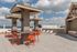 Chic rooftop terrace with modern pergolas, vibrant orange seating, and stylish lounge chairs under a picturesque sky.